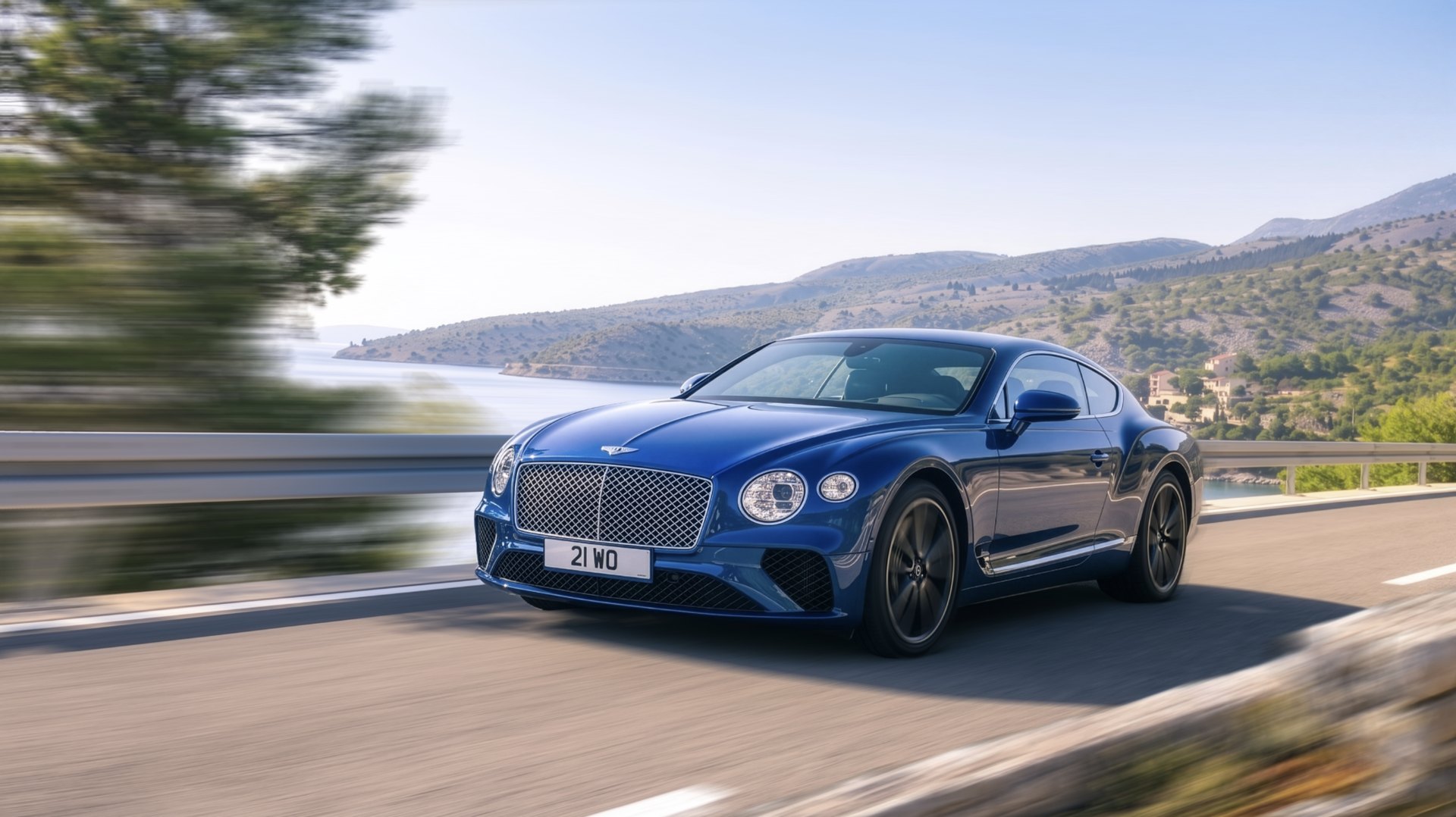 Bentley Continental GT on a coastal road, rendered in Vector//RIG: the car sharp, the background and wheels carrying photographic motion blur.